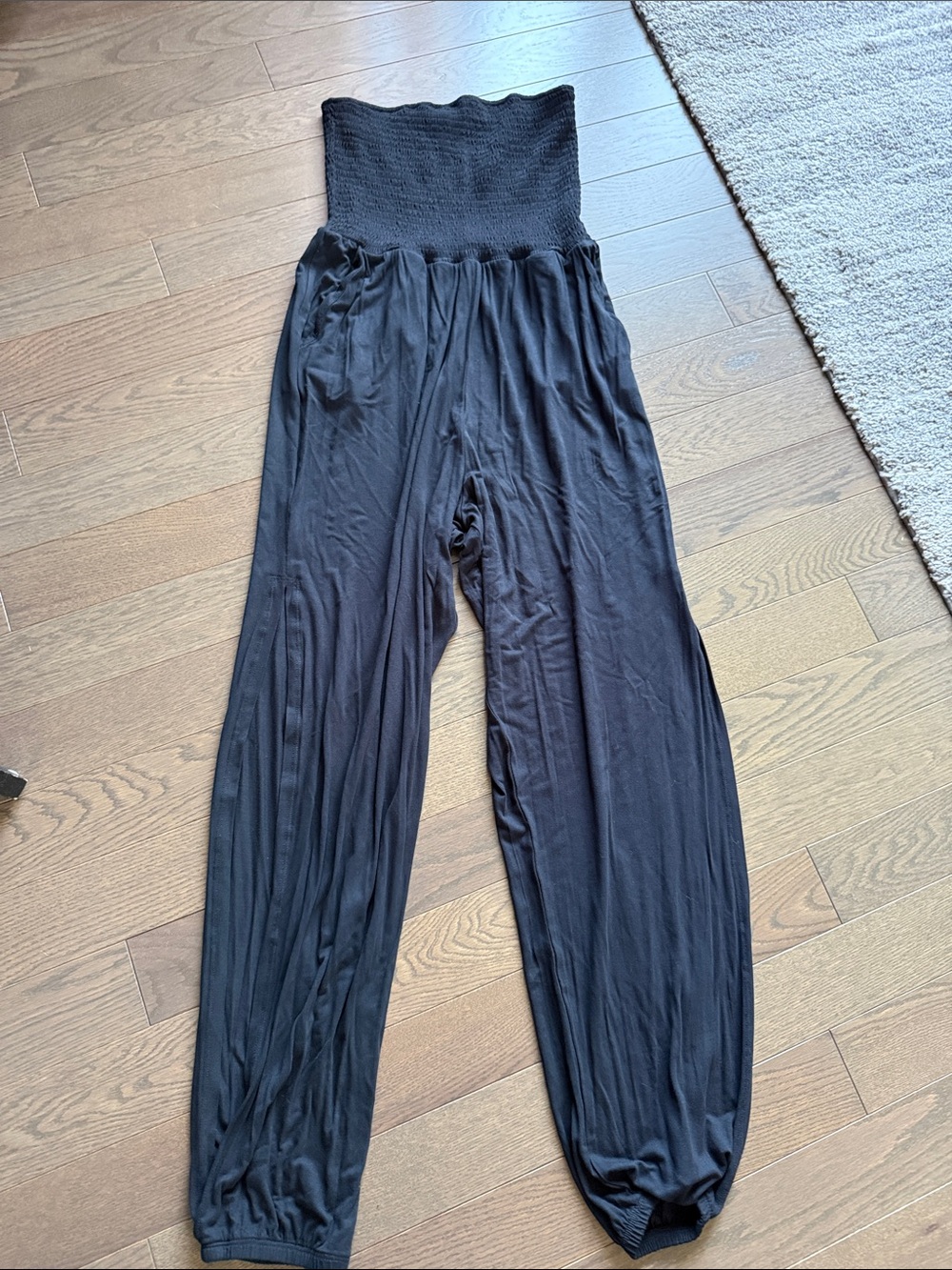 Women's Black Smocked jumpsuit with side leg slits.